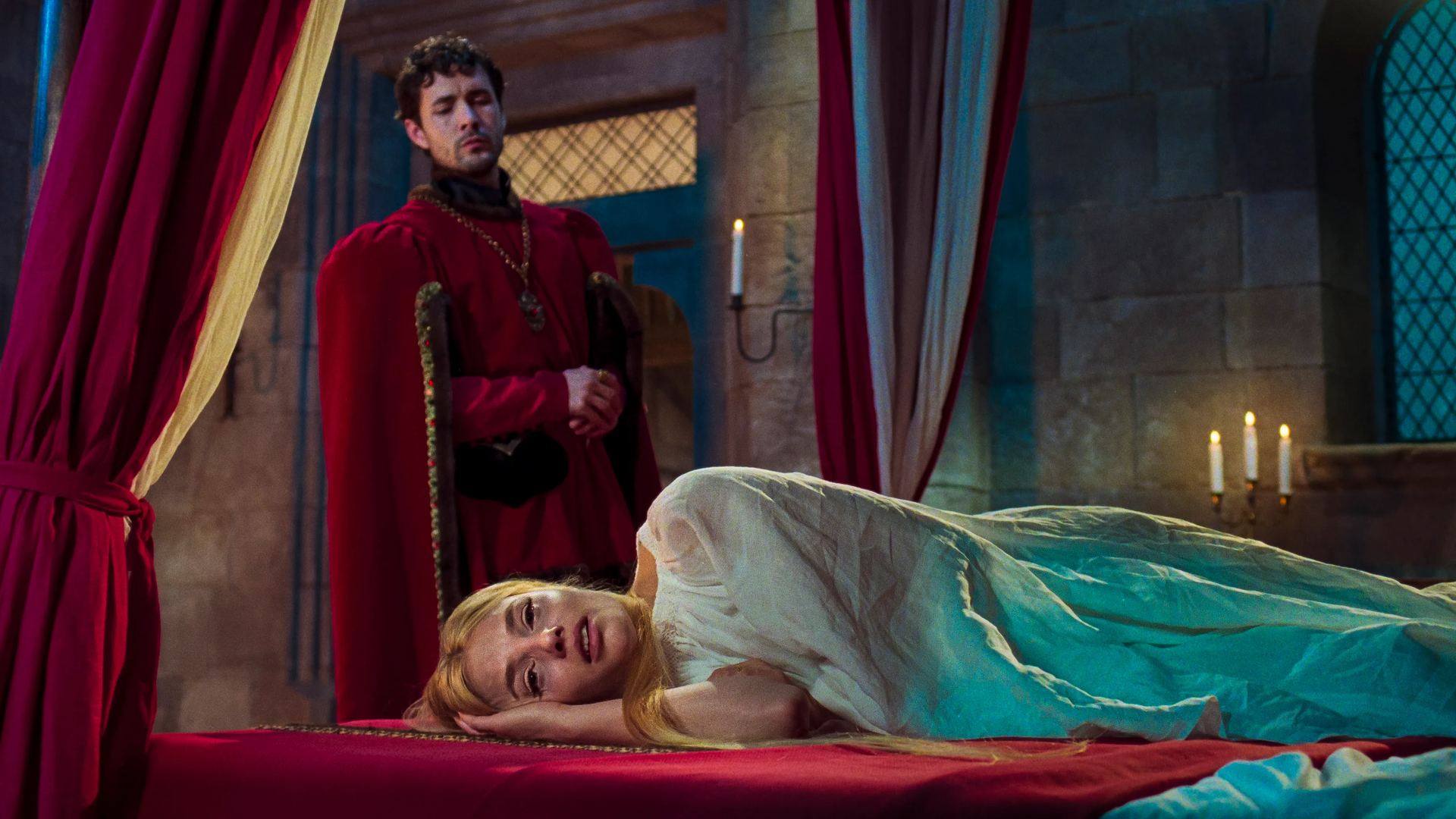 A woman reclining on a bed beside a man in red medieval clothing in The Face of Horror, directed by Anna Biller.